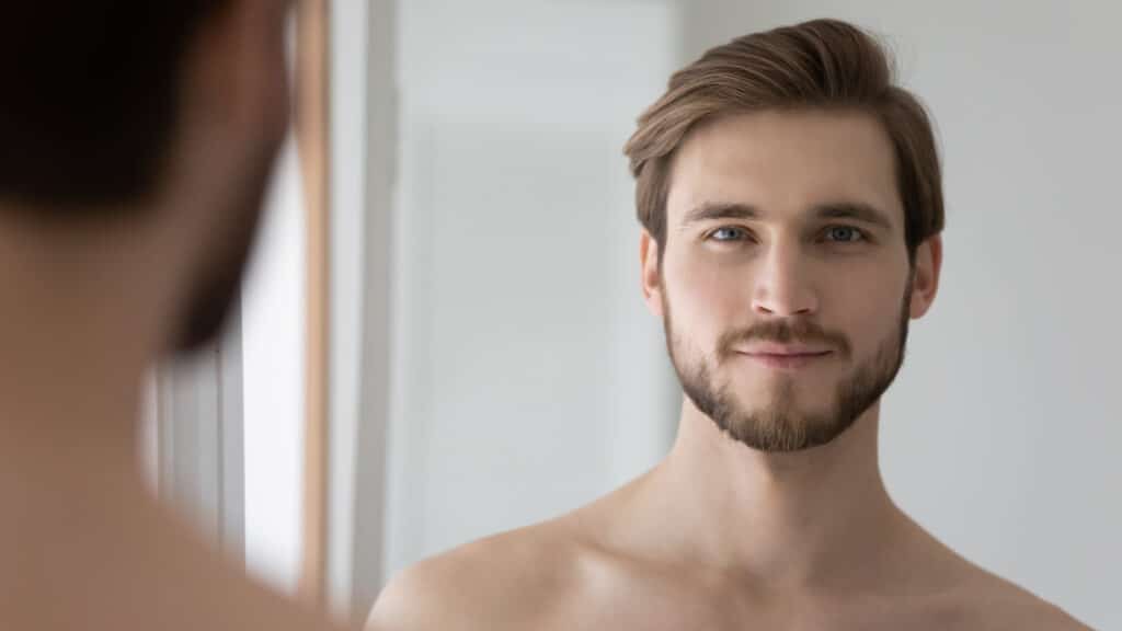 Young man smiles in the mirror before seeing his doctor