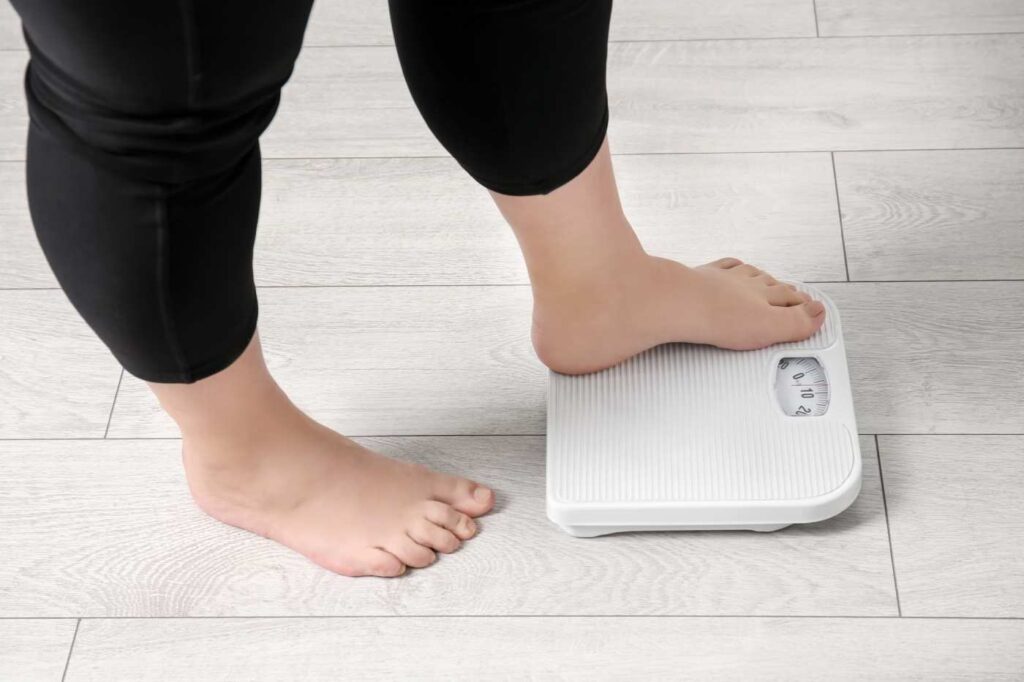 Woman's foot as she steps onto a scale to monitor weight loss
