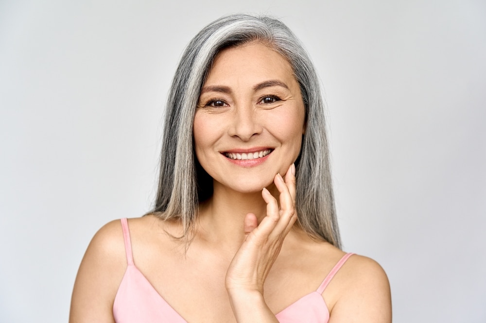 Gray haired woman smiles in San Antonio, feeling glad she detected heart disease early with concierge care